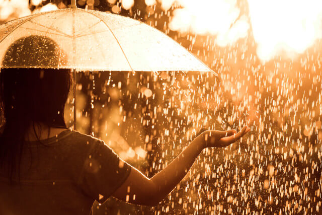 雨の中傘をさす女性